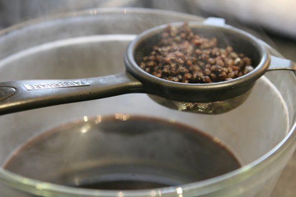 strain elderberries in mesh strainer